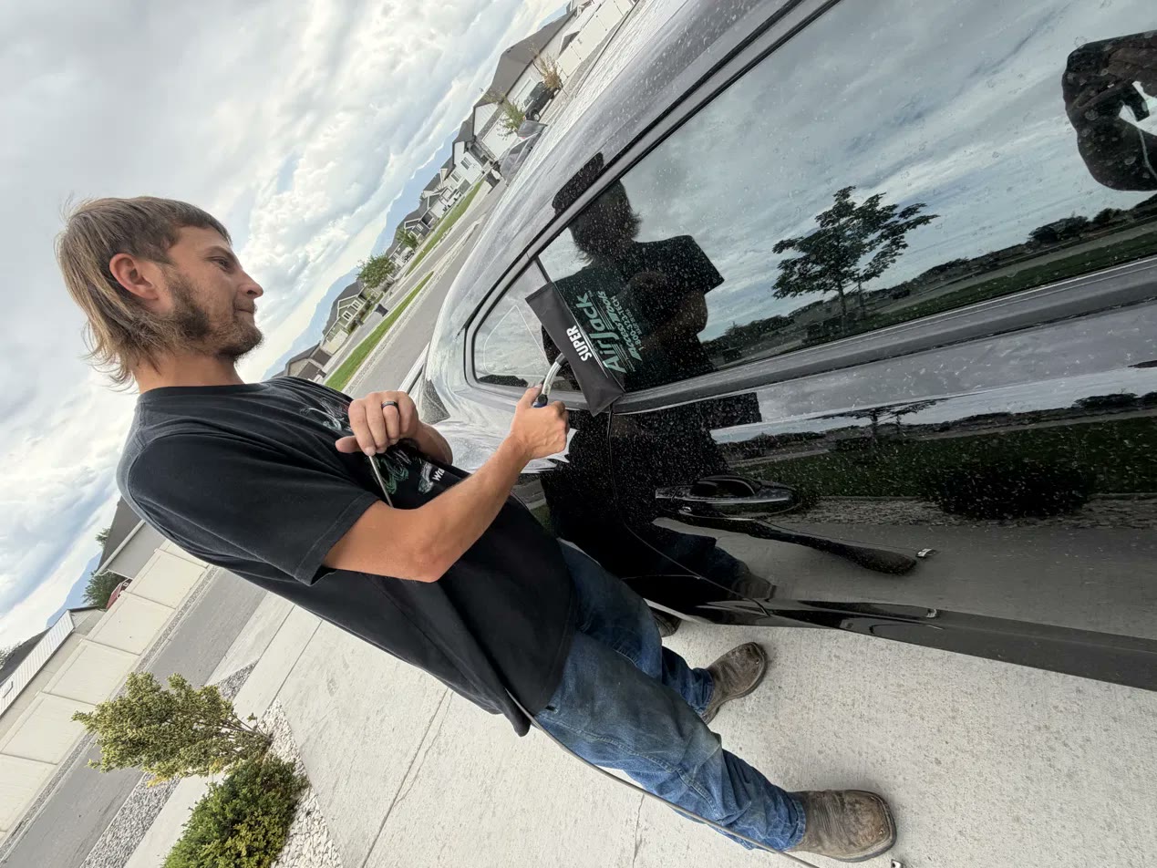 David using an air wedge to open a locked black SUV on a real lockout call, car and house lockout service