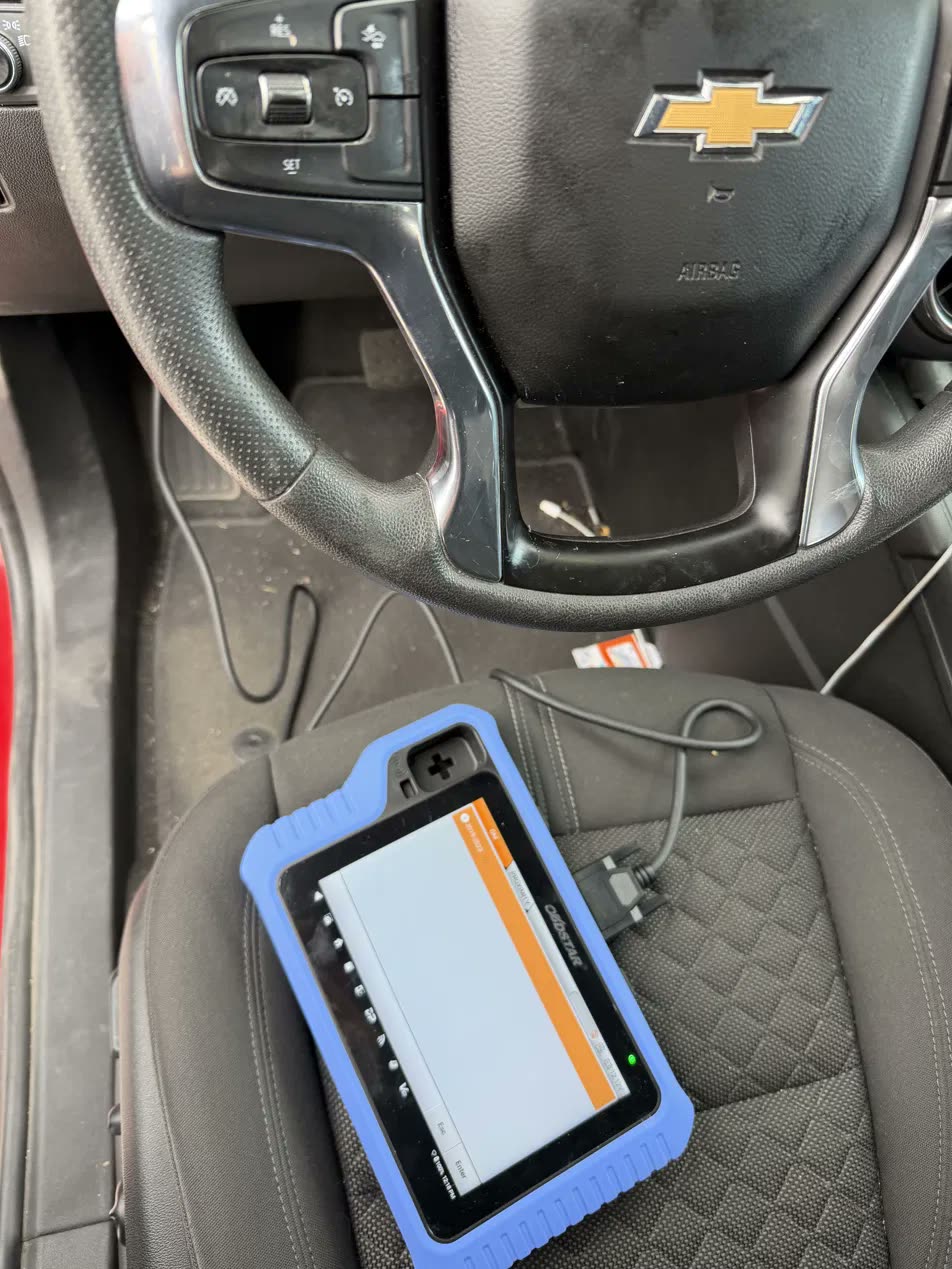 Key programmer connected inside a Chevy during fob programming